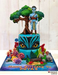 a blue cake with an image of a man standing on top of it and trees in the background