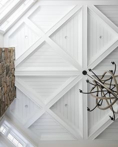 an overhead view of a living room with white walls and wood paneled ceilinging