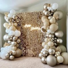 balloons are arranged in the shape of an arch with gold, silver and white decorations