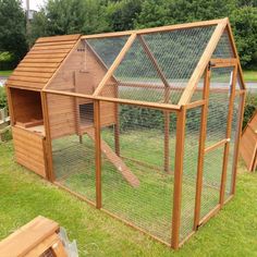 a large chicken coop in the middle of some grass