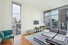 a living room filled with furniture and large windows