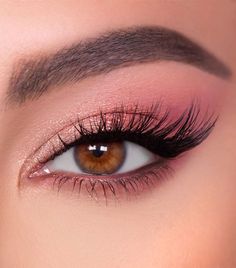 a woman's eye with long lashes and brown eyeshadow, close up