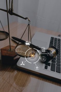 a laptop computer sitting on top of a wooden desk next to a judge's scale