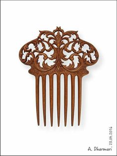 a wooden comb with intricate carvings on the front and back of it's sides