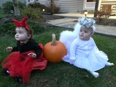 two children dressed up in costumes sitting on the grass