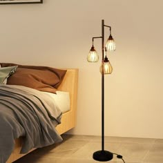 a lamp that is on top of a floor next to a bed in a room