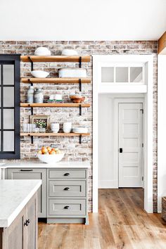 a brick wall in a kitchen with open shelving