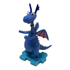 a blue dragon figurine sitting on top of a plastic base with its wings spread out