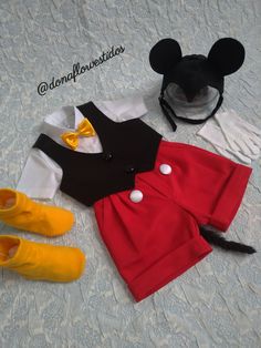 the mickey mouse outfit and shoes are on the bed