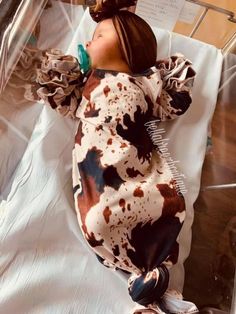 a baby doll laying on top of a white sheet in a hospital bed with an iv tube attached to it's head