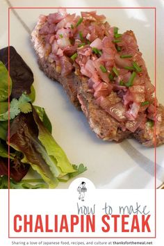 a white plate topped with meat next to lettuce and a green leafy salad