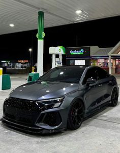 a grey car parked in front of a gas station