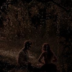 two people sitting in the woods at night