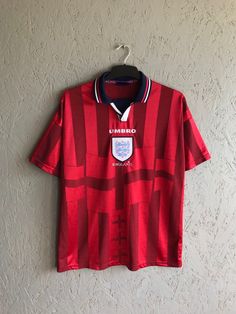 Vintage 90s UMBRO England T-Shirt / Rare Football Training T-Shirt / Vintage Jersey Shirt Team England / Red Color Size L Good used condition. Please check measurements:  - shoulder to shoulder  62  cm                                   (24,40inch) - sleeve length from shoulder  17  cm                       (6,69inch) - sleeve length from armpit  11  cm                            (4,33inch) - from armpit to armpit  56  cm                                  (22,04inch) - length on the back without a collar  74  cm          (29,13inch) +- Shipping worldwide: I accept combined worldwide delivery with tracking numbers. Postage: We do the shipment within 2 days. Estimated shipping time: 10-28 working days (in rare cases it takes longer). Canada 20-60 days  Look at my other items for sale. Before y Red Retro Sports Top, Red Retro Sports T-shirt, 90s Style Red T-shirt For Sports, 90s Style Short Sleeve Fan Merchandise Shirt, 90s Fan Merchandise Short Sleeve Shirt, 90s Style Fan Merchandise Short Sleeve Shirt, Vintage Red T-shirt For Sports, Red Top With Sublimation Print And Short Sleeves, Red Short Sleeve Top With Sublimation Print