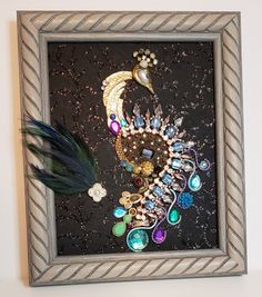 there is a framed picture with beads and feathers on it