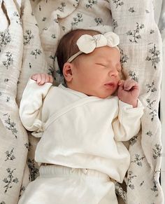 a baby laying on top of a white blanket