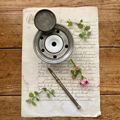 an old recipe book with a teapot and spoon on it next to a flower