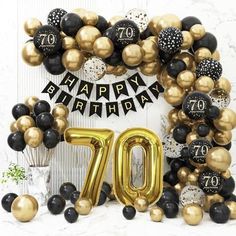 a 70th birthday decoration with balloons and streamers in black, gold and white colors