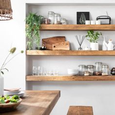 the shelves in this kitchen are filled with plants and other things to drink or eat