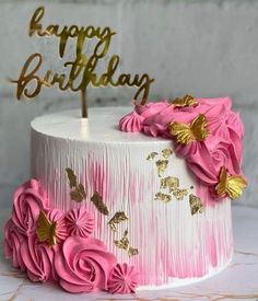 a birthday cake with pink flowers and gold butterflies on top is decorated with the words happy birthday