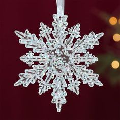 a snowflake ornament hanging from a christmas tree