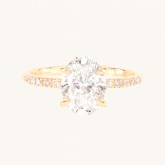 a yellow gold ring with an oval cut diamond