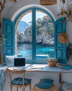 a laptop computer sitting on top of a table next to an open window with blue shutters