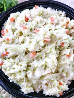 a black bowl filled with coleslaw and carrots