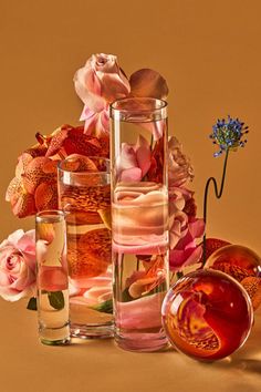 several vases filled with different types of flowers on top of a brown tablecloth