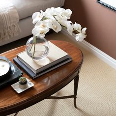 a vase with white flowers on top of a coffee table