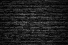 an old brick wall is shown in black and white with the light shining on it