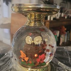 a glass vase with an owl in it on top of a plastic wrapper covered table