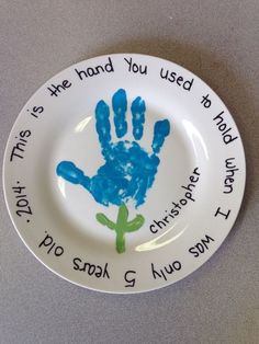 a white plate with blue handprints on it that says, this is the hand you used to hold today