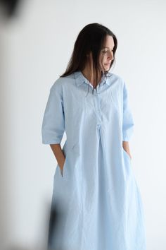 Manuelle Guibal Easy Dress in color Blue Ice Medium weight, tea length with a quarter button down and adjustable cinch tie closure at back. Features three quarter length sleeves, ruched details, collared neck and pockets at hips. 70% Cotton 30% Linen Made in France Peter Pan Collar Blouse, Easy Dress, Petal Sleeve, Blue Ice, Hair Accessories Gift, Collar Blouse, Tea Length, Peter Pan Collar, Sleeve Detail