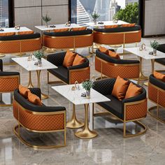 a room filled with lots of tables covered in orange and black chairs sitting next to each other