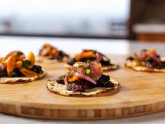 small appetizers are arranged on top of a wooden cutting board