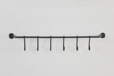 a metal rack with five hooks on it