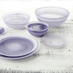 purple glass bowls and plates on a white table