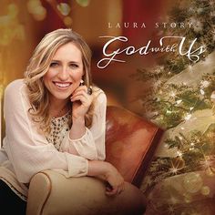 a woman sitting on top of a chair next to a christmas tree with lights in the background