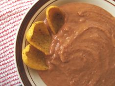 a plate with some tortilla chips on it and chocolate dip in the middle