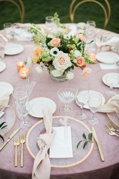 the table is set with plates, silverware and napkins for an elegant dinner