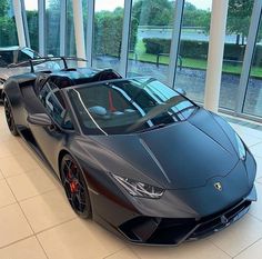 two black sports cars parked in front of large windows