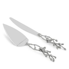 two forks and spoons sitting next to each other on a white surface with leaves