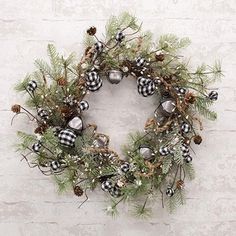 a christmas wreath hanging on the wall with pine cones and baubes in it