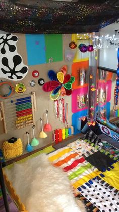 there is a bed with lots of colorful items on the headboard and foot board