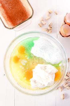 eggs, yogurt and other ingredients in a glass bowl on a white table