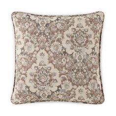 a brown and white pillow with an ornate pattern on the front, sitting on a white background