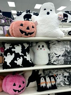 several halloween pillows are on display in a store aisle with ghost, pumpkins and other decorations