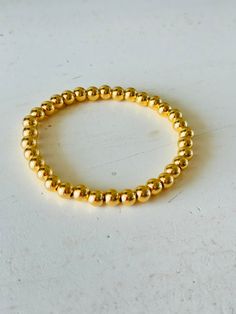 Add some trendy bling to your wrist with our Halo 6mm Gold Bracelet. This stretch bracelet features gleaming gold plated 6mm beads that are sure to catch the eye. Elevate any outfit with this stylish and versatile accessory. Sold individually Gold Plated Stainless Steel 6mm bead bracelet Stretch bracelets fit most Price is for one but shown as examples of sets Flexible Gold Beaded Bracelets, Gold Stackable Stretch Bangle Bracelet, Adjustable Gold Stretch Bracelet Stackable, Classic Gold Stretch Bracelet For Everyday, Everyday Gold Stretch Bangle Bracelet, Classic Gold Hypoallergenic Beaded Bracelets, Adjustable Gold Stretch Bracelet Hand-strung, Adjustable Gold Stretch Bracelet For Everyday, Adjustable Stackable Gold Stretch Bracelet