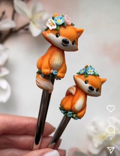 two little foxes are sitting on top of each other with flowers in their hair,